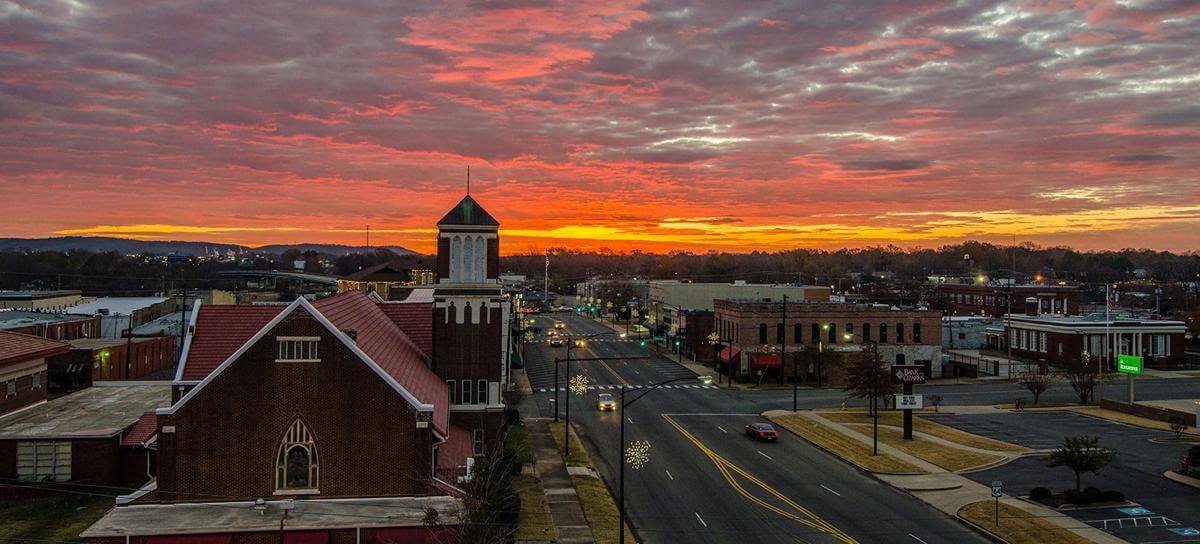 Downtown Russellville beneath a vivid orange and pink sunset